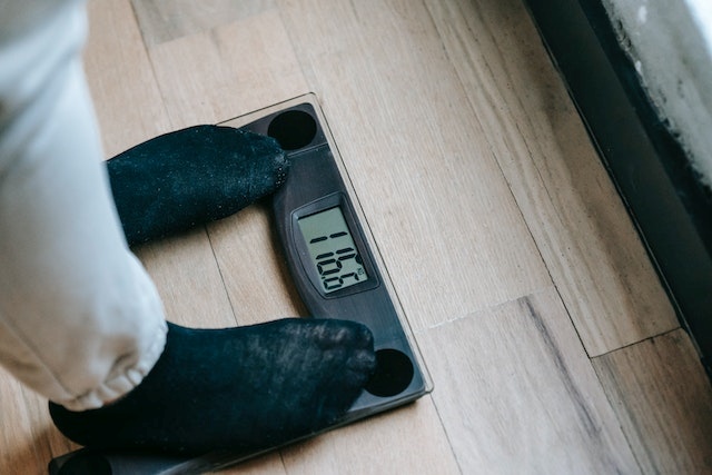 A person standing on a weighing scale to check weight